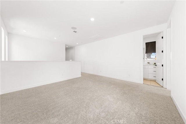 unfurnished room featuring recessed lighting, light colored carpet, and baseboards