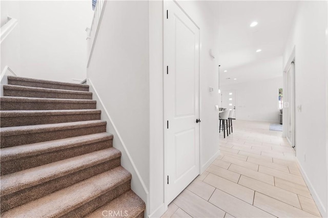 stairs featuring baseboards and recessed lighting