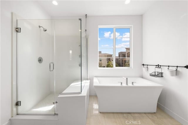 bathroom featuring a stall shower, a freestanding bath, and recessed lighting