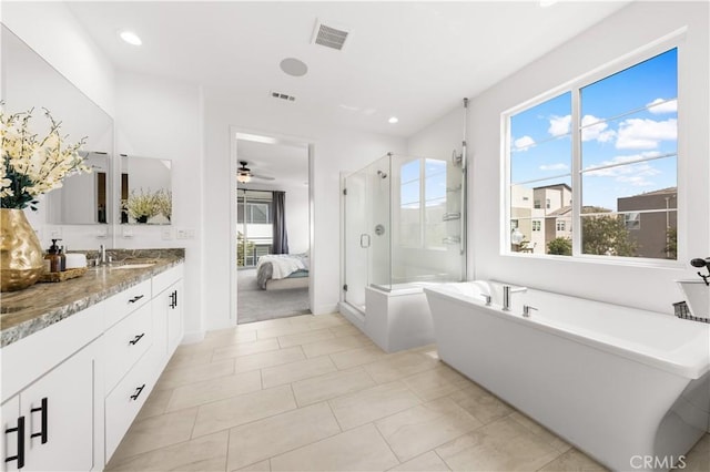 full bath featuring ensuite bathroom, vanity, visible vents, a freestanding bath, and a stall shower