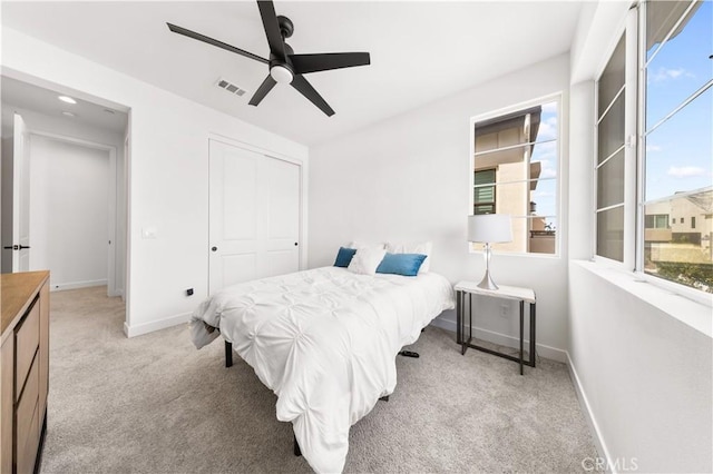 bedroom with a closet, carpet, visible vents, and baseboards