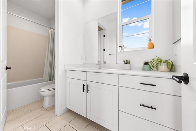 full bath featuring toilet, shower / bath combo with shower curtain, and vanity