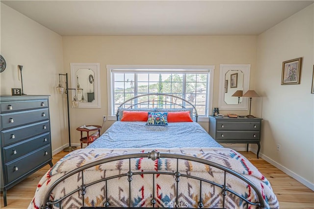 bedroom with baseboards and wood finished floors