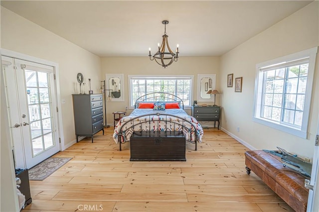 bedroom with baseboards, multiple windows, and light wood finished floors