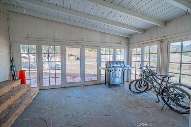 unfurnished sunroom with vaulted ceiling with beams