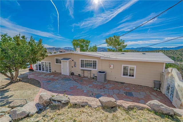 rear view of house with a patio, central AC, and a mountain view