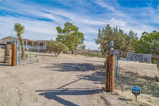 view of road with driveway, a gated entry, and a gate