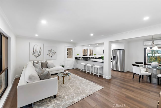 living room featuring ornamental molding, dark wood-type flooring, baseboards, and recessed lighting