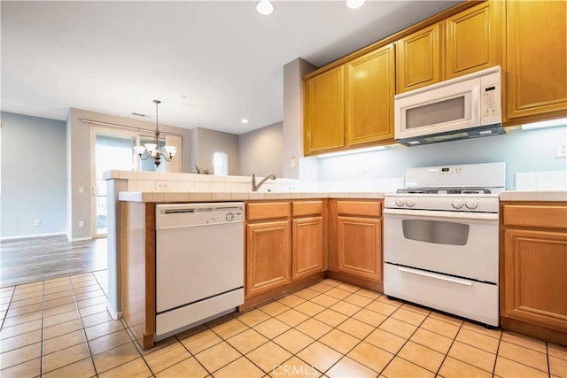 kitchen featuring tile counters, recessed lighting, a chandelier, white appliances, and a peninsula