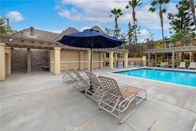 pool with a patio area, fence, and a pergola