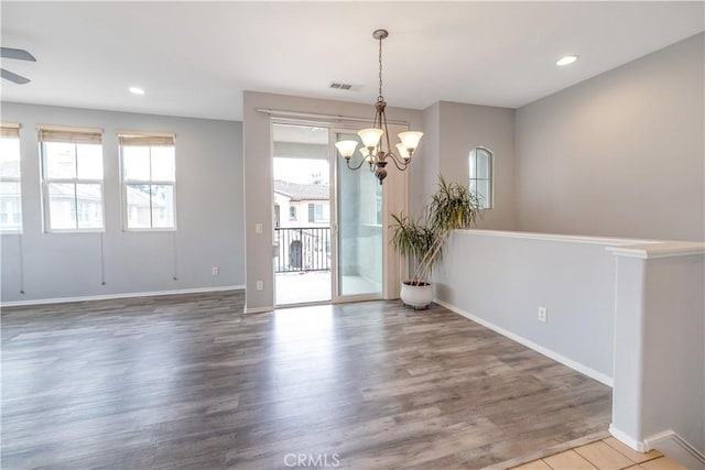 spare room with plenty of natural light, wood finished floors, and recessed lighting