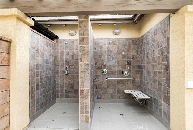 bathroom featuring a skylight and a tile shower