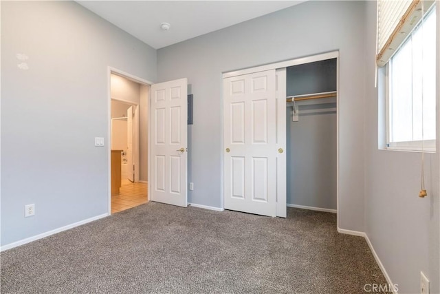 unfurnished bedroom featuring a closet, carpet flooring, and baseboards