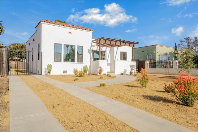 view of front of house with a pergola, a gate, fence, and stucco siding