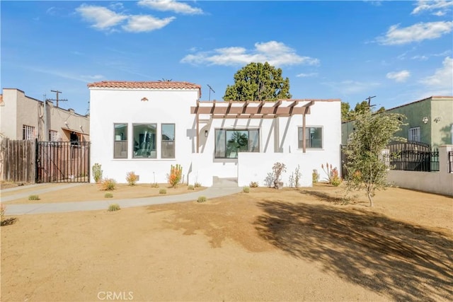 mediterranean / spanish-style home with a gate, stucco siding, and fence