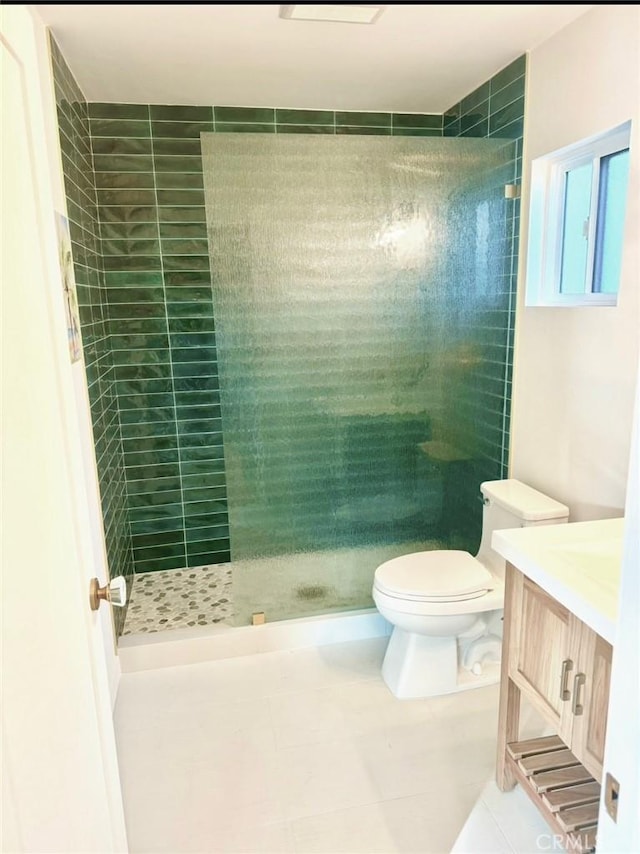 bathroom with toilet, vanity, a stall shower, and tile patterned floors