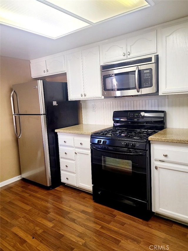 kitchen featuring white cabinets, stainless steel appliances, and dark wood-type flooring