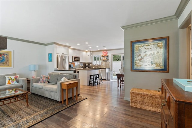 living area featuring baseboards, recessed lighting, wood finished floors, and crown molding