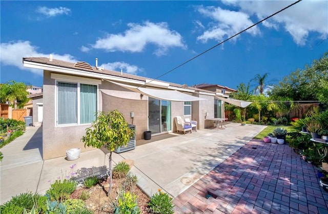 back of property with a patio area, fence, and stucco siding