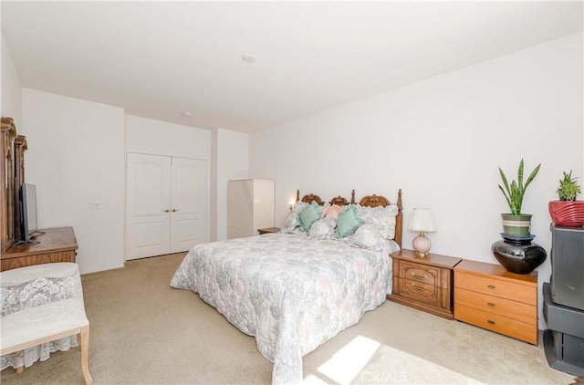 bedroom with a closet and light colored carpet