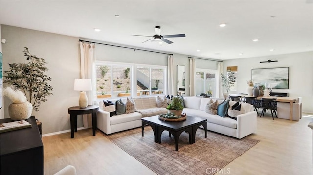 living area featuring light wood finished floors, ceiling fan, baseboards, and recessed lighting