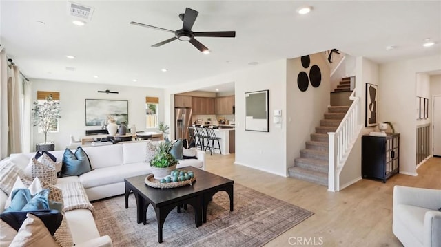 living area featuring light wood finished floors, visible vents, a ceiling fan, stairs, and recessed lighting