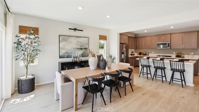 dining space with baseboards, recessed lighting, and light wood-style floors