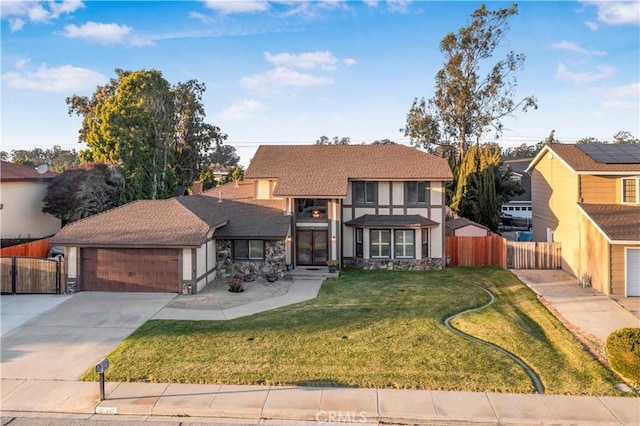 view of front facade featuring stucco siding, driveway, fence, a front yard, and a garage