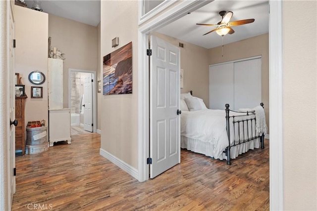 bedroom featuring a ceiling fan, visible vents, baseboards, and wood finished floors