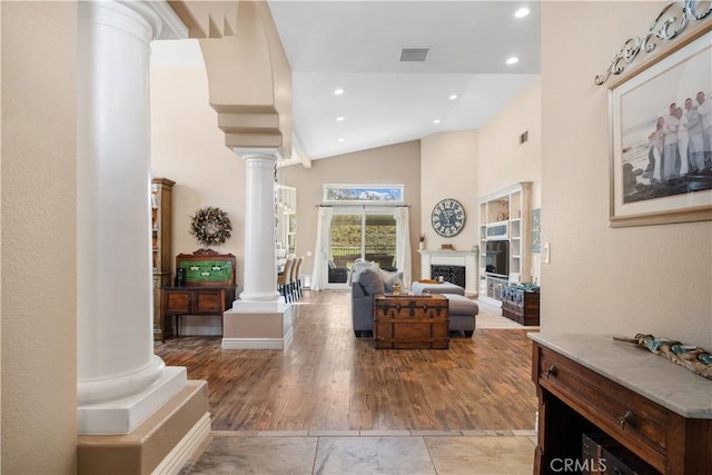 living room with high vaulted ceiling, recessed lighting, a fireplace, visible vents, and ornate columns