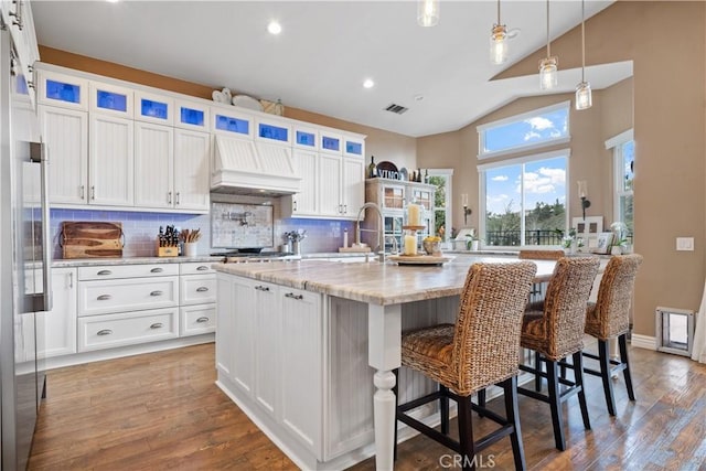 kitchen featuring a sink, visible vents, white cabinets, custom exhaust hood, and wood-type flooring