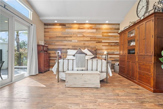 bedroom featuring access to outside, wooden walls, light wood-style flooring, and recessed lighting