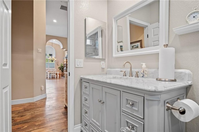 bathroom with baseboards, visible vents, wood finished floors, and vanity