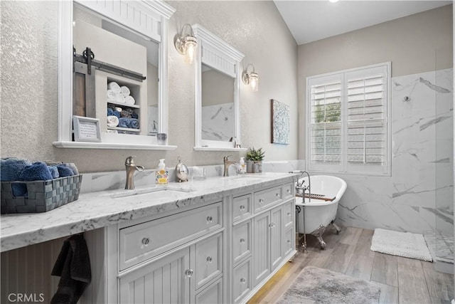 full bath featuring a sink, a marble finish shower, and wood finished floors