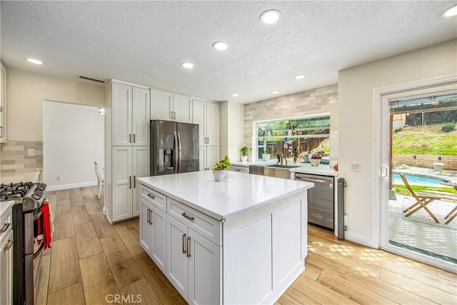 kitchen featuring light countertops, appliances with stainless steel finishes, light wood-type flooring, and visible vents