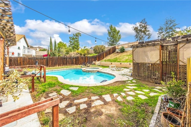 view of swimming pool with a fenced backyard and a pool with connected hot tub