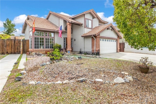 traditional home featuring a garage, concrete driveway, brick siding, and fence