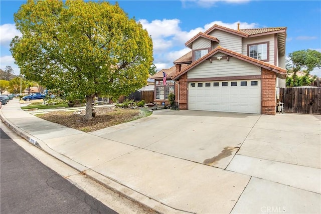 view of front of house featuring a garage, concrete driveway, brick siding, and fence