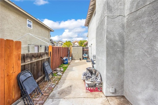 view of patio / terrace with a storage unit, an outdoor structure, and fence