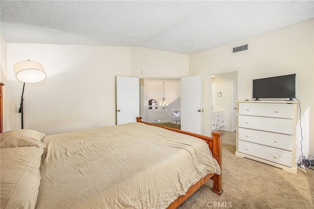 bedroom with carpet, visible vents, and a textured ceiling