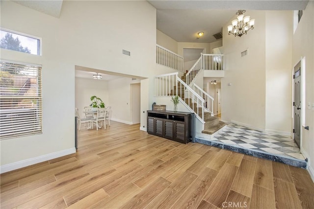 entryway featuring wood finished floors, visible vents, and an inviting chandelier