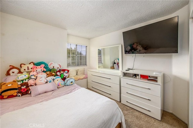 bedroom featuring a textured ceiling and light colored carpet