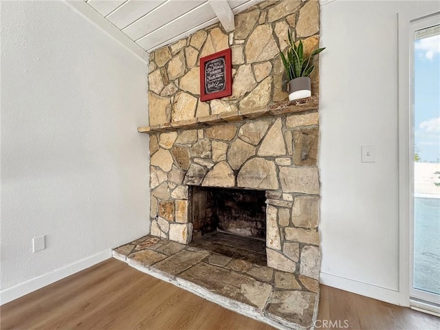 interior details with a fireplace, wood finished floors, and baseboards