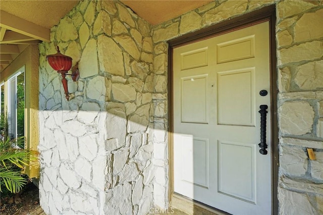 property entrance with stone siding