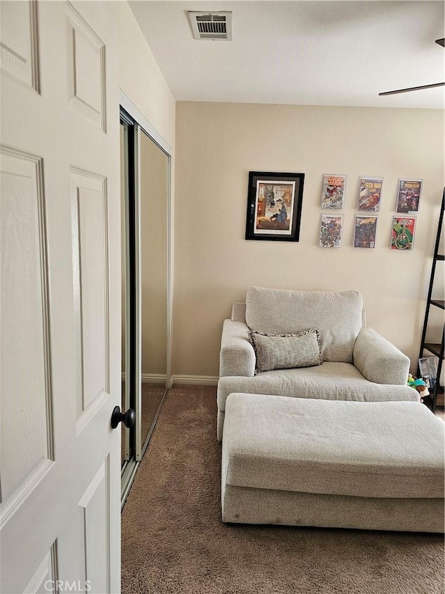 living area with carpet, visible vents, and baseboards