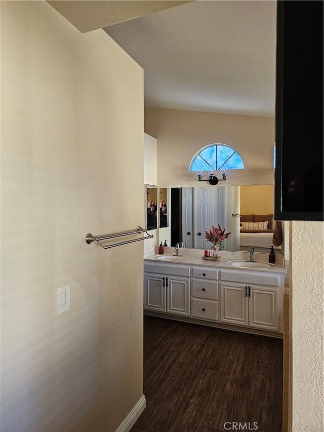 full bathroom featuring double vanity, a sink, and wood finished floors