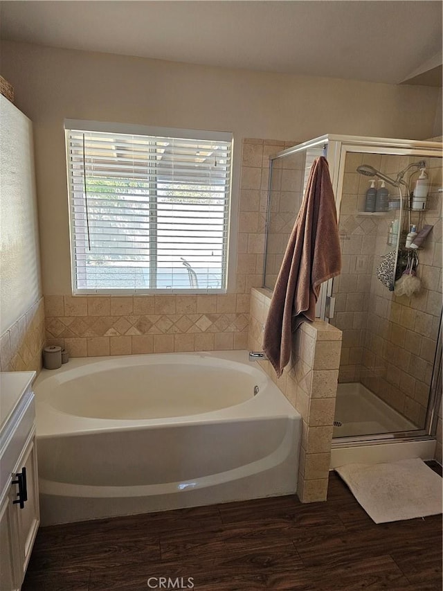 full bath featuring a garden tub, a stall shower, and wood finished floors