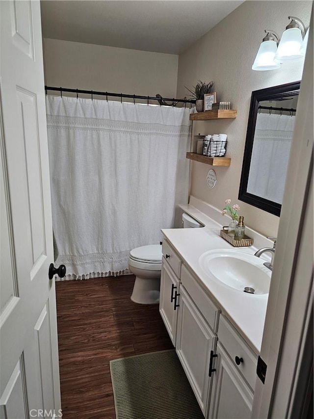 bathroom featuring vanity, wood finished floors, toilet, and a shower with curtain