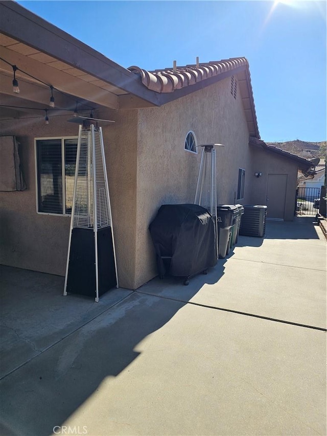 view of property exterior featuring a patio area, a ceiling fan, and stucco siding