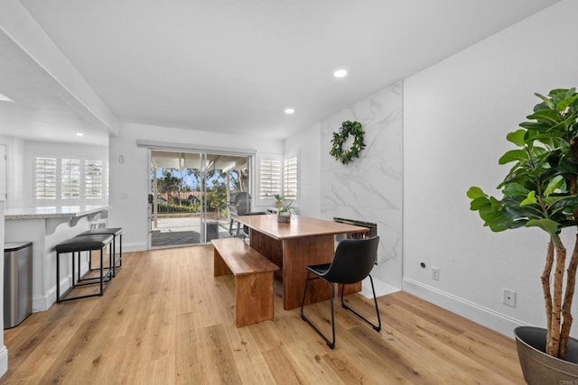 dining area with light wood-type flooring, a fireplace, baseboards, and recessed lighting